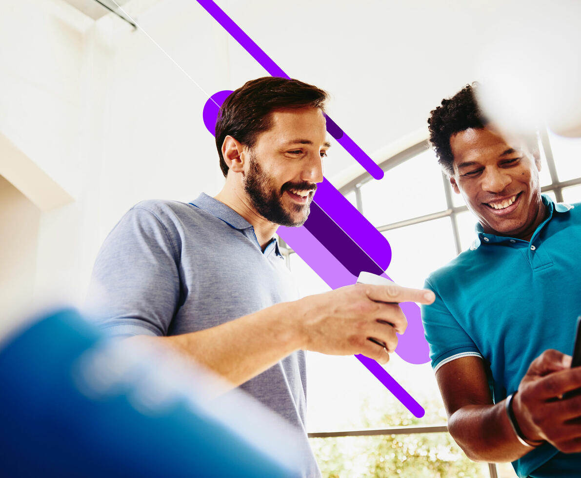 an image of a two smiling men looking at a phone