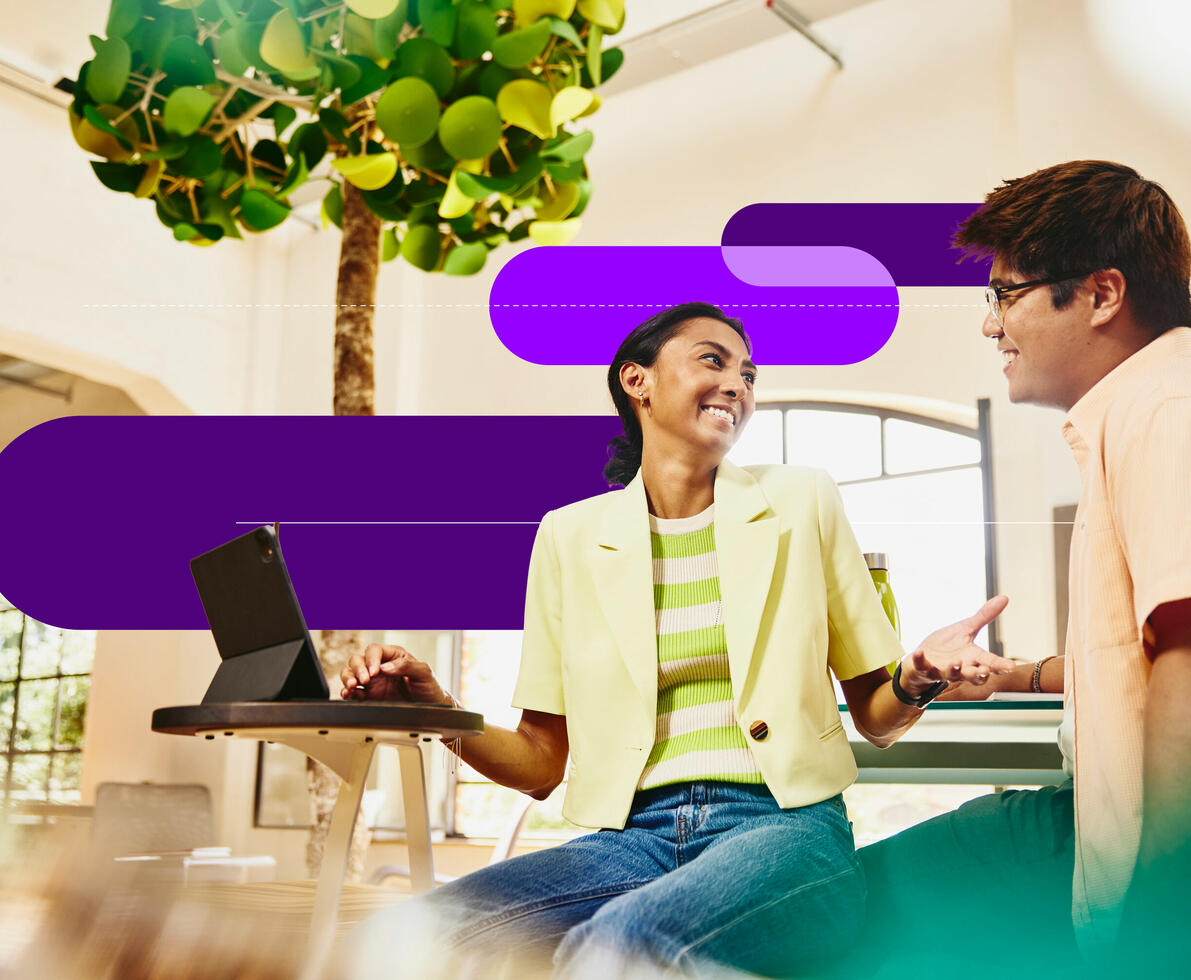 an image of two coworkers talking with a tablet on the table in front of the woman