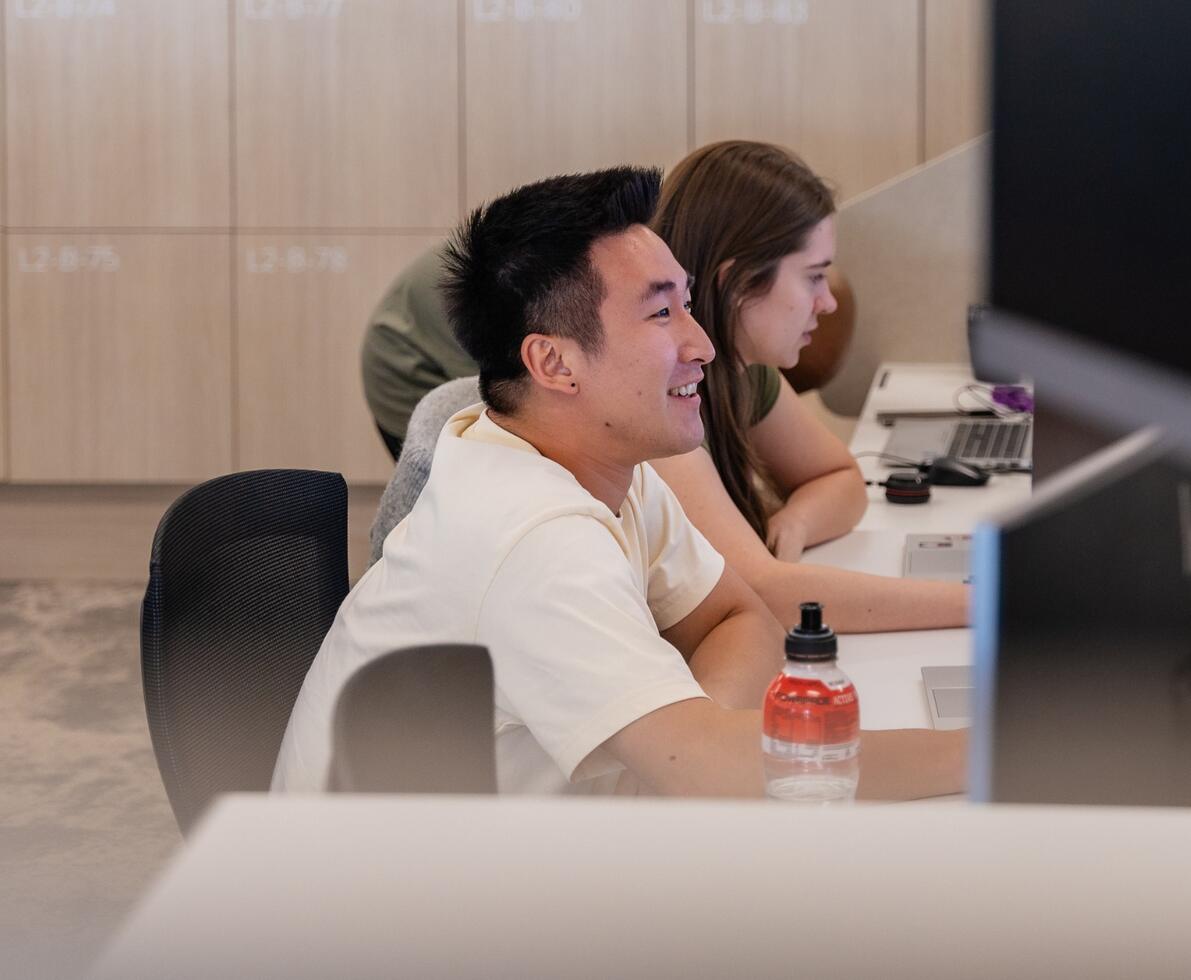 an image of a man looking at his computer screen while smiling 