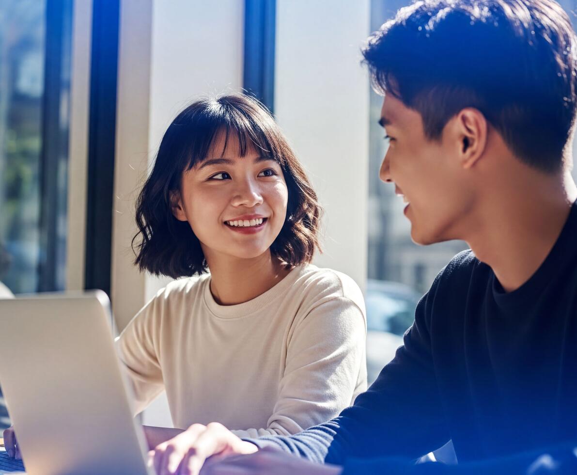 male and female office workers sitting together with a laptop