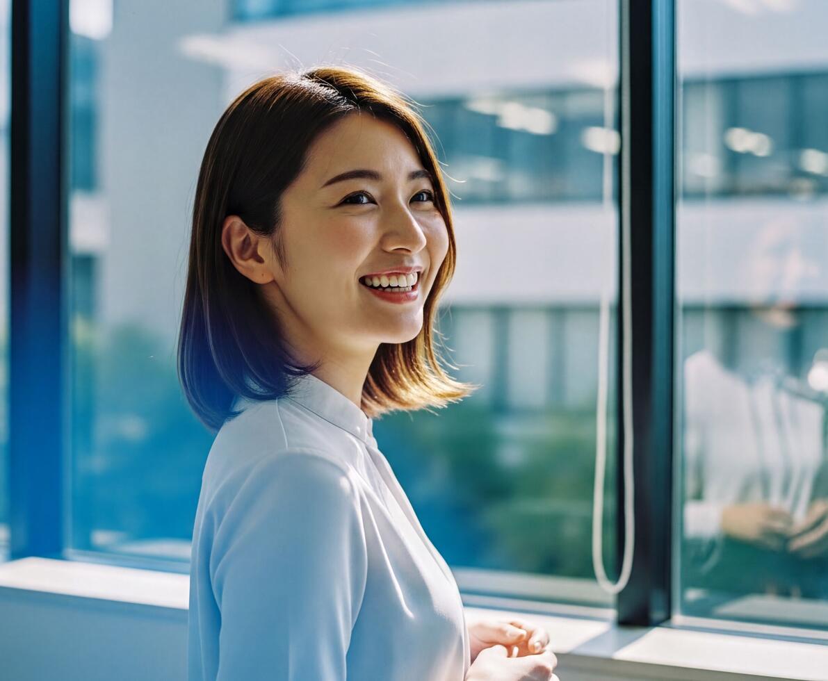 woman smiling standing by a window in an office
