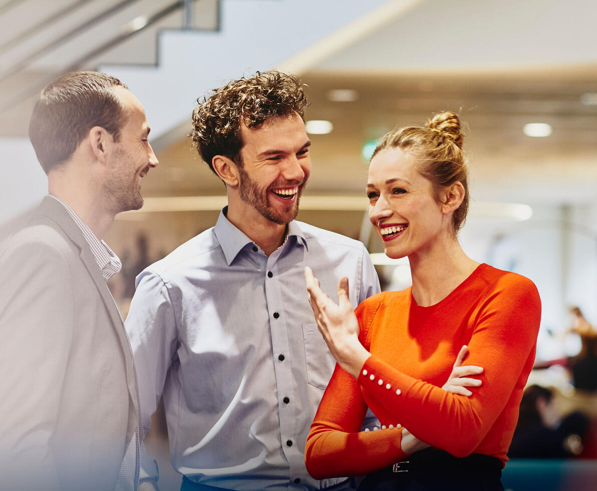 a group of colleagues together in an office having a conversation