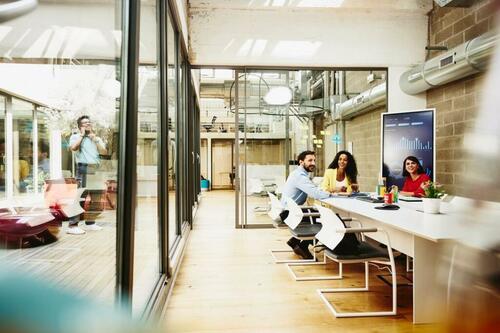 group of workers sitting at a desk in an office