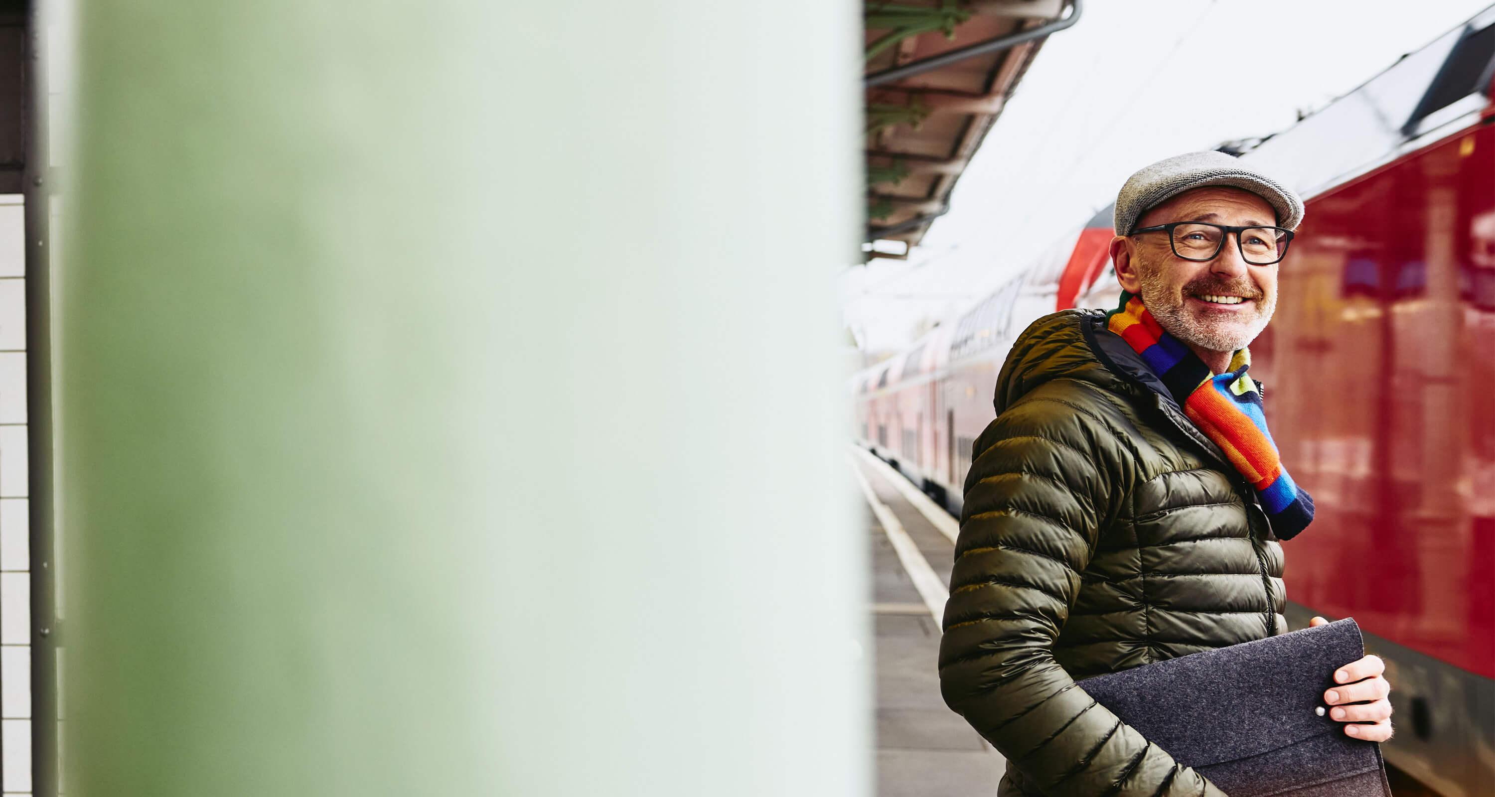A photo of a man looking to apply for a job while standing in front of a train waiting