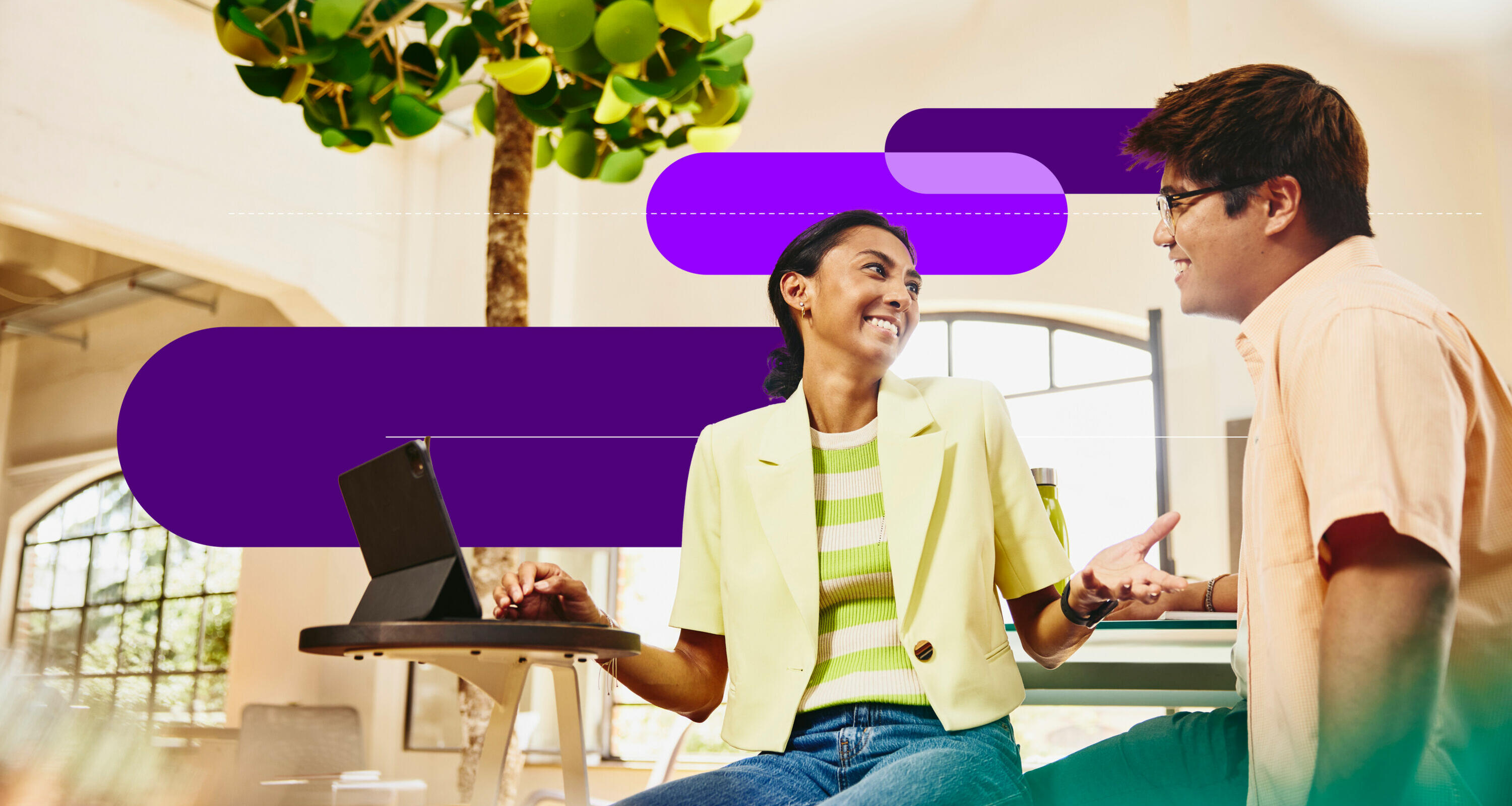 an image of two coworkers talking with a tablet on the table in front of the woman