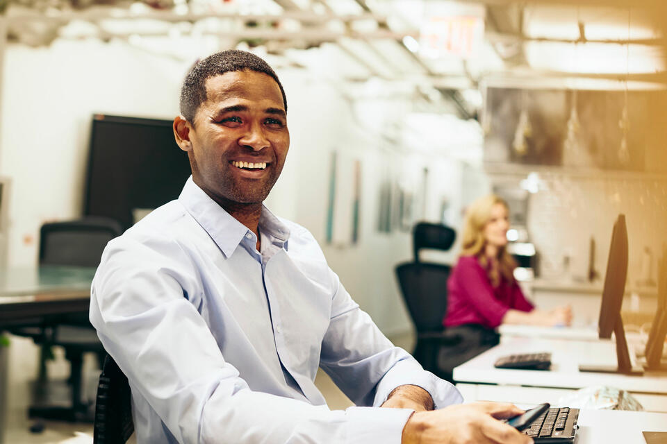 Close up - Smiling male looking away behind a desk