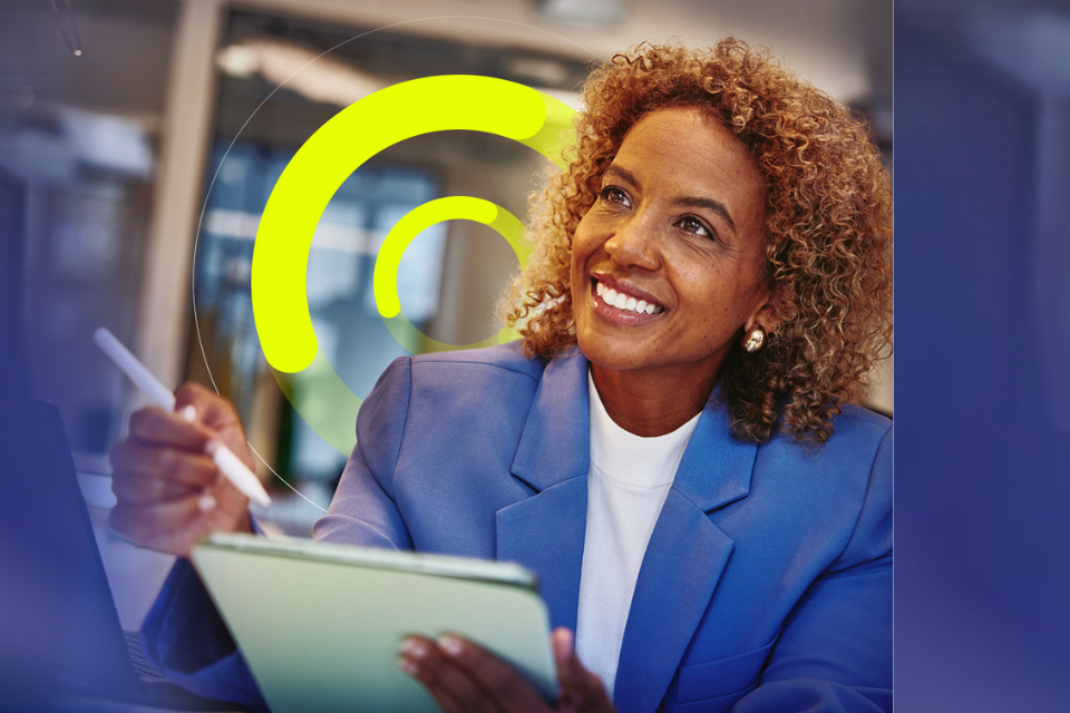 an image of a woman holding a tablet and stylus smiling brightly