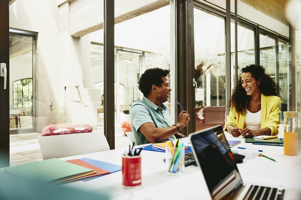 male and female having a laugh during a meeting in a meeting room.
