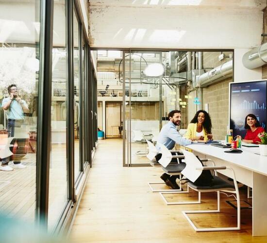 group of workers sitting at a desk in an office