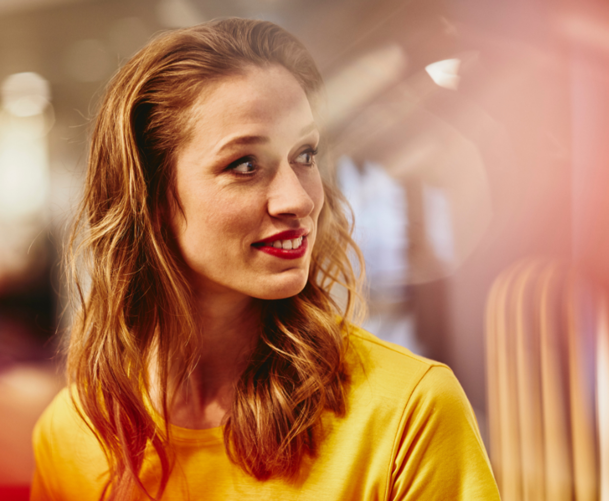 A woman in a yellow shirt looking at a distance A woman in a yellow shirt looking at a distance